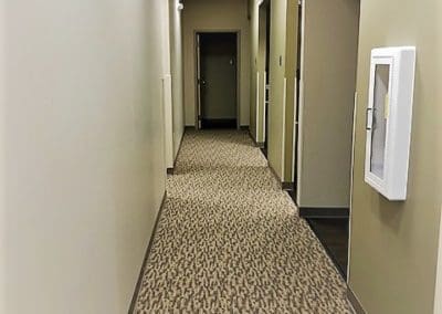 A hallway with many tan and beige carpet.